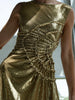 Close-up of a model wearing a gold sequin dress with gathered tuck detailing in a circular motion and adjustable waist cut out 